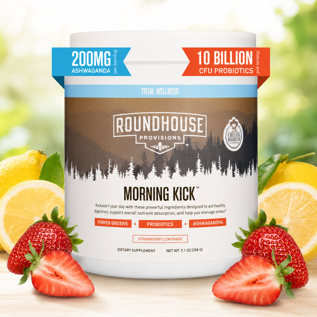 Roundhouse Provisions Morning Kick supplement container with lemons and strawberries on a wooden surface.